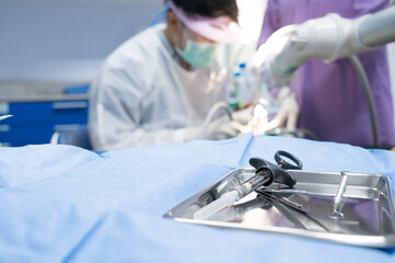 Selective focus dental equipment for dentist and blurry dentist examining patient tooth on dental chair at dental department.Medical mouth and tooth health care concept.