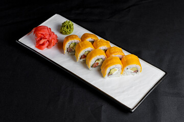 Sushi Rolls with processed cheese cheddar, american cheese, avocado, tuna and cream cheese inside on white slate