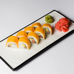 Sushi Rolls with processed cheese cheddar, american cheese, avocado, tuna and cream cheese inside on white slate