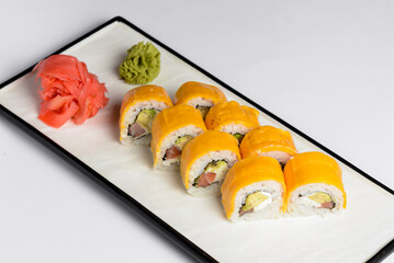 Sushi Rolls with processed cheese cheddar, american cheese, avocado, tuna and cream cheese inside on white slate