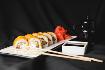 Sushi Rolls with processed cheese cheddar, american cheese, avocado, tuna and cream cheese inside on white slate