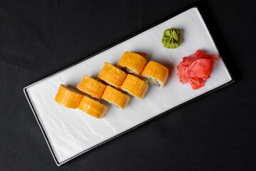 Sushi Rolls with processed cheese cheddar, american cheese, avocado, tuna and cream cheese inside on white slate