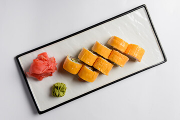 Sushi Rolls with processed cheese cheddar, american cheese, avocado, tuna and cream cheese inside on white slate