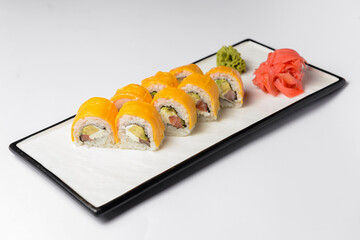 Sushi Rolls with processed cheese cheddar, american cheese, avocado, tuna and cream cheese inside on white slate