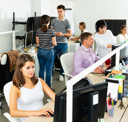 Positive efficient glad people working with computers and laptops in modern office