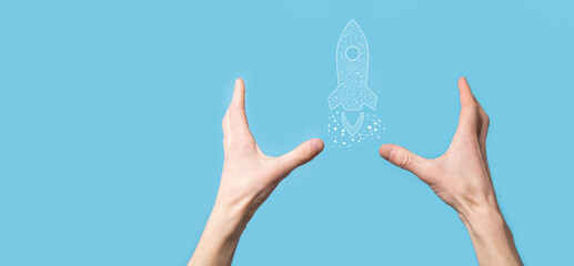 Male hand holding digital transparent rocket icon.Startup business concept. Rocket is launching and soar flying.Concept of business idea.