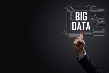 Businessman in a suit on a dark background holds the inscription BIG DATA. Storage Network Online Server Concept.Social network or business analytics representation