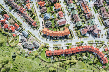 Fototapeta premium aerial top view of residential houses in suburban area at sunny summer day