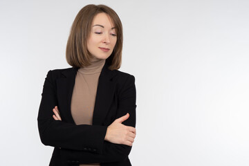 Portrait of a woman dressed in a business style. She looks down with her arms crossed. Businesswoman on a white background. Concept - sale of business clothes for girls. Women business clothing