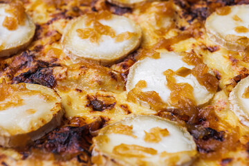Close-up of pizza topped with goat cheese and caramelized onion. Macro shot of delicious products.