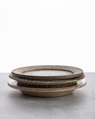 handmade ceramics, empty craft ceramic plates on light background 