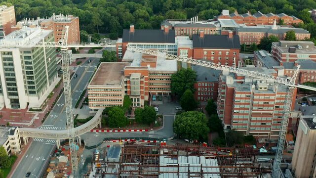 Medical research hospital under construction at UNC Chapel Hill. Heavy cranes and equipment revealed by aerial tilt up.