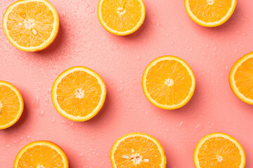 Fototapeta na wymiar Top view photo of juicy orange slices and water drops on isolated light pink background
