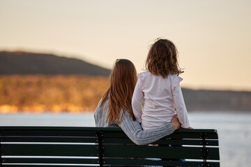 Mother and daughter sharing time together on sunset at beach