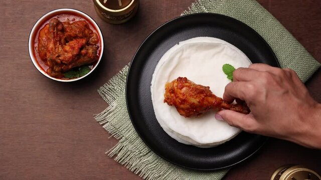 Hand eating Rice pathiri Pathiri flat bread coconut milk, chicken curry Kerala Tamil Nadu India SriLanka. traditional South Indian breakfast dish Malabar Muslims Ramadan Ramzan, Eid festival Rice roti