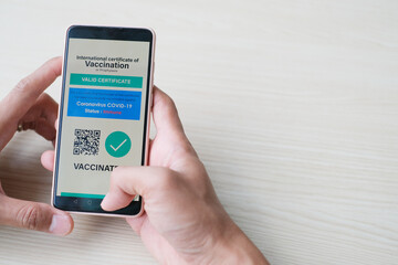 Close up hand using mobile show valid digital COVID19 vaccination certificate. New normal travel concept.The digital health certificate is required for international travel during coronavirus pandemic