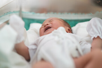 close up of new born infant asleep in the blanket in delivery room
