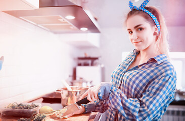 A cute young girl in the kitchen prepares food
