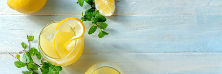 Lemonade panorama with copy space. Homemade fresh lemon beverage, shot from above on a wooden...