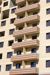 Construction a multi-storey building. High-rise brick house with windows