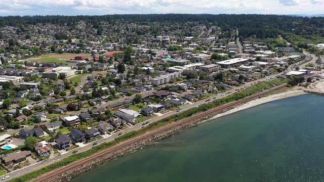 Cinematic 4K drone footage of the downtown Edmonds commercial area, Kingston ferry terminal waterfront marina, shoreline, Sunset beach near Seattle, Washington, Pacific Northwest, in Snohomish County