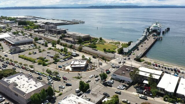Cinematic 4K drone footage of the downtown Edmonds commercial area, loading Kingston ferry, terminal, waterfront marina, near Seattle in Washington, Pacific Northwest, in Snohomish County