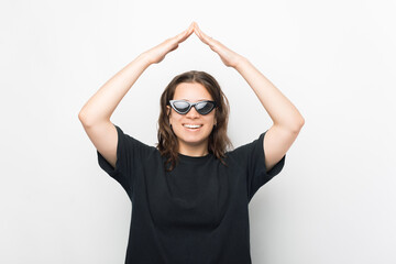 Portrait of beautiful young trendy woman making roof gesture over white background