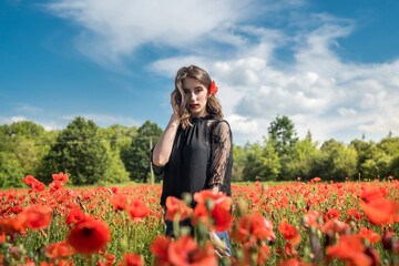 Young woman walking on red poppy field, summer time