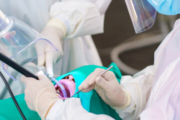 The doctor cleaning the teeth patient with ultrasonic tool