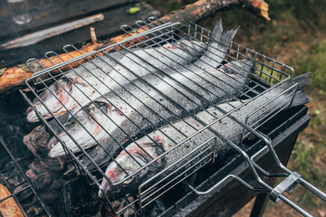 Marinated seabass carcasses on the grill - BBQ fish with less fat