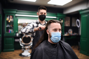 Fototapeta na wymiar Man client visiting haidresser in barber shop, coronavirus and new normal concept.