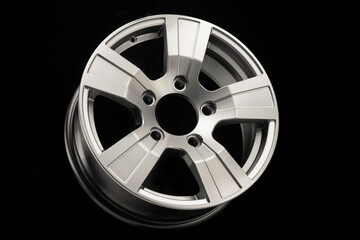 Obraz premium new silver alloy wheels for SUVs on black background, side view