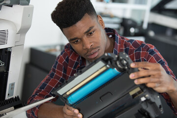 a repairman examining ink cartridge