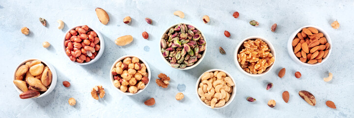 Nuts panorama on a slate background. Peanuts, walnuts, almonds and various other nuts, top shot