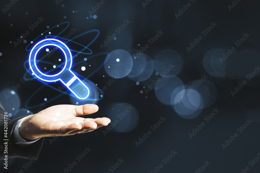 Poster businessman hand holding glowing magnifier icon hologram on blurry bokeh background with mockup plac
