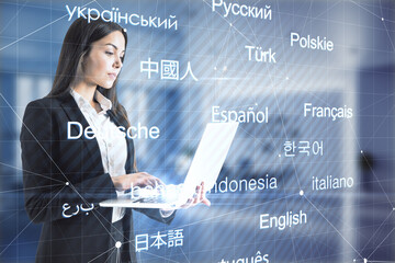 Attractive young european businesswoman with laptop standing in blurry office interior with...