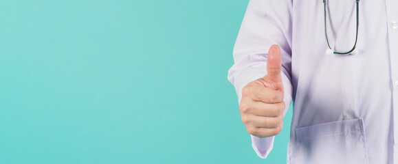 Doctor do a thump up hand sign on mint green or tiffany blue background.