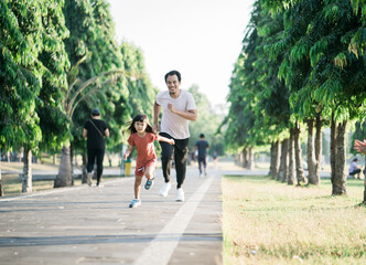 Fototapeta na wymiar father and daughter do exercises running outdoor racing each other. Healthy lifestyle of family with child