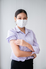 Young women wearing masks standing show plaster bandage at the shoulder. After vaccine protection coronavirus 19 for immunization. Concepts to prevent the spread of COVID-19.