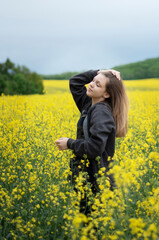 Fototapeta premium Young girl on yellow rapeseed field