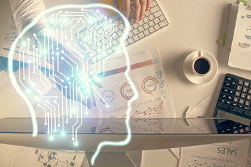 Double exposure of man's hands typing over computer keyboard and brain hologram drawing. Top view. Ai and data technology concept.
