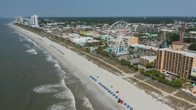 Wide aerial of Myrtle Beach South Carolina oceanfront shoreline. Atlantic Ocean family vacation destination in USA. Establishing shot in summer.