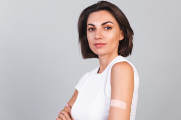 Young woman after vaccination Showing Arm With Plaster Bandage. Virus protection. COVID-2019.