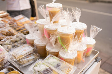various kinds of traditional Indonesian street food, kolak with plastic cups wrapped in plastic on a serving plate on the table
