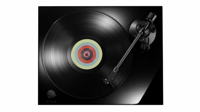Top view of vinyl record with colorful label spinning on black turntable with carbon tonearm