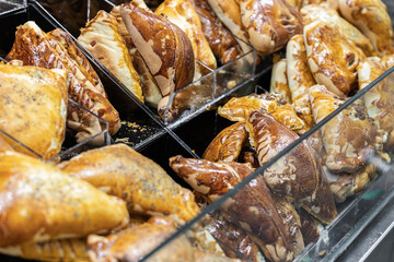 Empanada is a baked or fried pastry and meat, cheese, tomato, corn, or other ingredient stuffed filling common in Southern European, Latin American, and the Philippines cultures