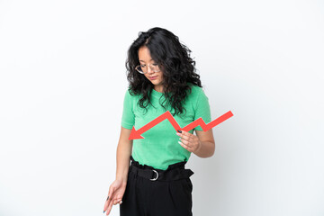 Young asian woman isolated on white background holding a downward arrow and with sad expression