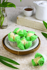 Bolu Kukus Pandan or Flower bloom steam cake, Indonesian traditional cake, with pandan leaves flavour. White bright background. Morning tea concept.