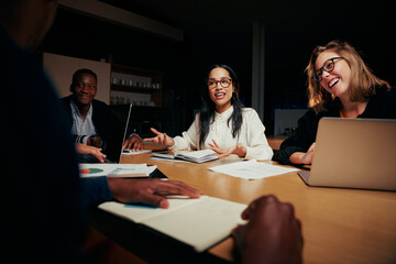 Happy diverse group of businesspeople sitting at table working together in office