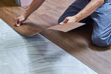 worker joining vinyl floor covering at home renovation - 442093994